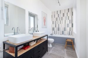 Salle de bains rénovée avec meuble double vasque baignoire et sanitaires